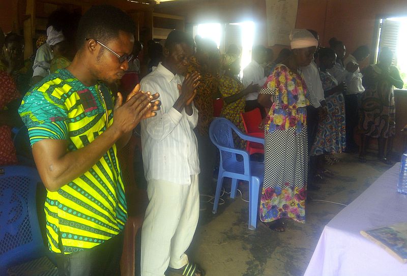 photo inside, a row of people in prayer.